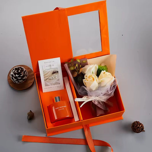 Coffret cadeau bien-être premium avec bougie parfumée, diffuseur d’ambiance et fleurs décoratives, présenté dans une élégante boîte cadeau orange. Idéal pour offrir.